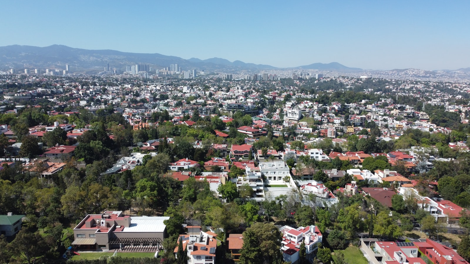 Aerial view of Mexico City with buildings and mountains in the background
